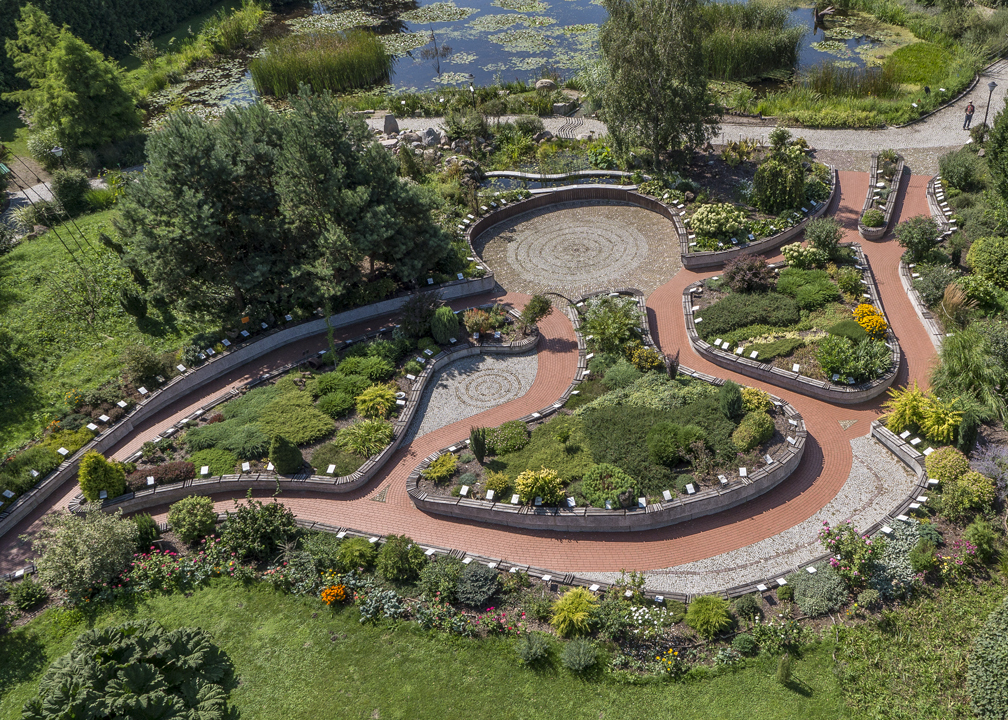 Widok na ogród sensualny z boku, pokazuje okrągły plac, rośłiny i alejki.